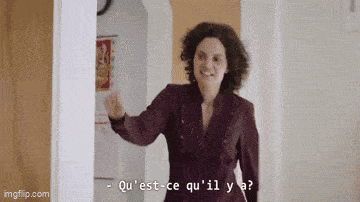 a woman standing in a hallway with the words qu 'est-ce qu 'il y a written on the screen