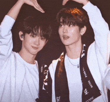 two young men are standing next to each other and one has a scarf around his neck that says keita park in black letters