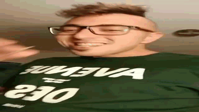 a man wearing glasses and a green shirt with the word oe3 on it