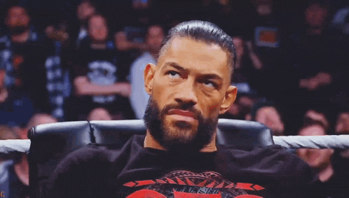 a man with a beard is sitting in a chair with his eyes closed in a ring .