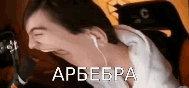 a man wearing headphones is laughing in front of a microphone .