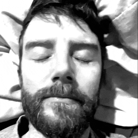 a man with a beard has his eyes closed