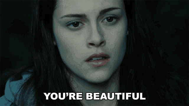 a close up of a woman 's face with the words " you 're beautiful " below her