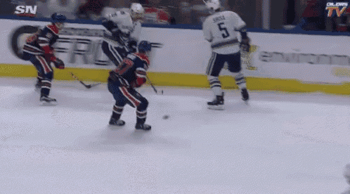 a hockey player with the number 5 on his jersey is playing defense