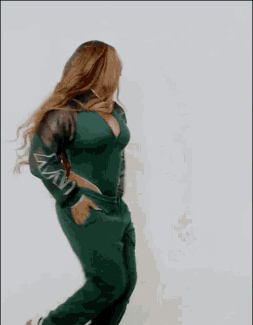 a woman with long hair is standing in front of a white wall .
