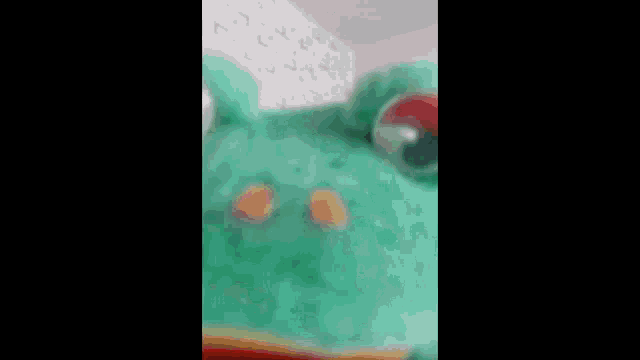 a person is holding a green puppet that looks like a dinosaur .