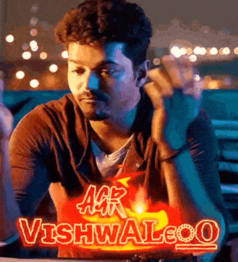 a man sitting in front of a sign that says agr vishwaleo