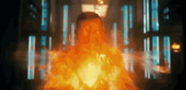 a man is surrounded by flames and smoke in a dark room