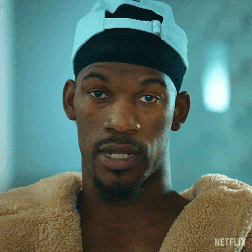 a close up of a man wearing a hat and a jacket with netflix written on it