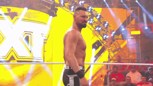 a wrestler is standing in a ring with the letter x in the back
