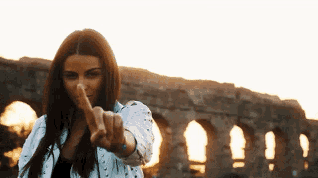 a woman is pointing her finger at the camera