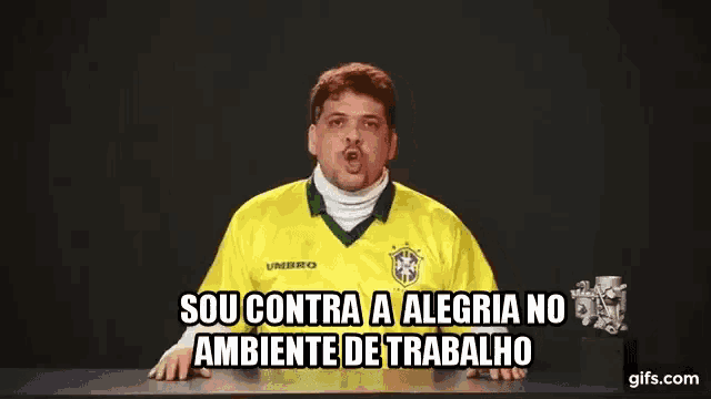 a man wearing a yellow umbro jersey is sitting at a table
