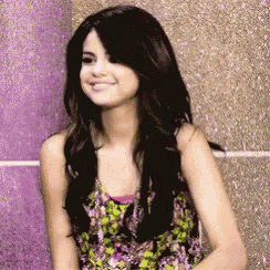 a woman in a floral tank top is smiling