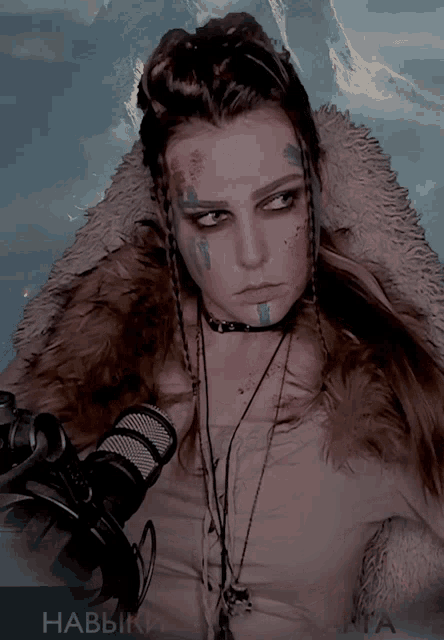a woman in a fur coat is holding a microphone and has the name habbik on the bottom