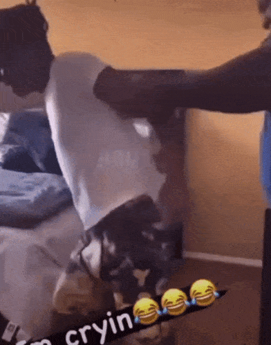 a man in a white shirt is being punched in the face by another man in a room .