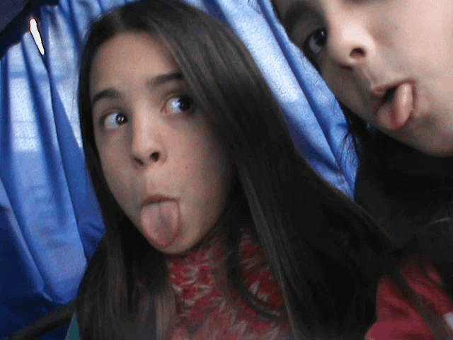 two girls sticking their tongues out in a photo