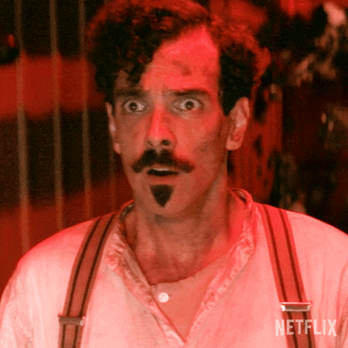a man with a surprised look on his face has a netflix logo on his shirt