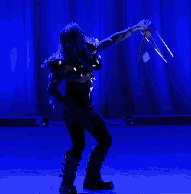 a person in a dark room with a blue curtain