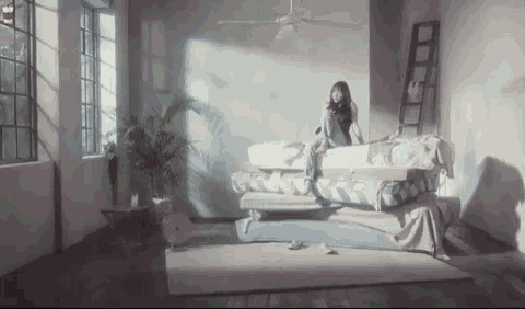 a woman is sitting on top of a mattress in a room .