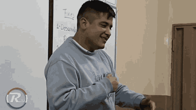 a man stands in front of a white board that says finer