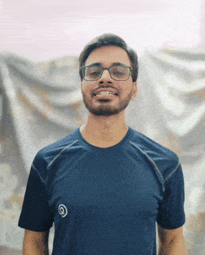 a man wearing glasses and a blue t-shirt with the letter q on it