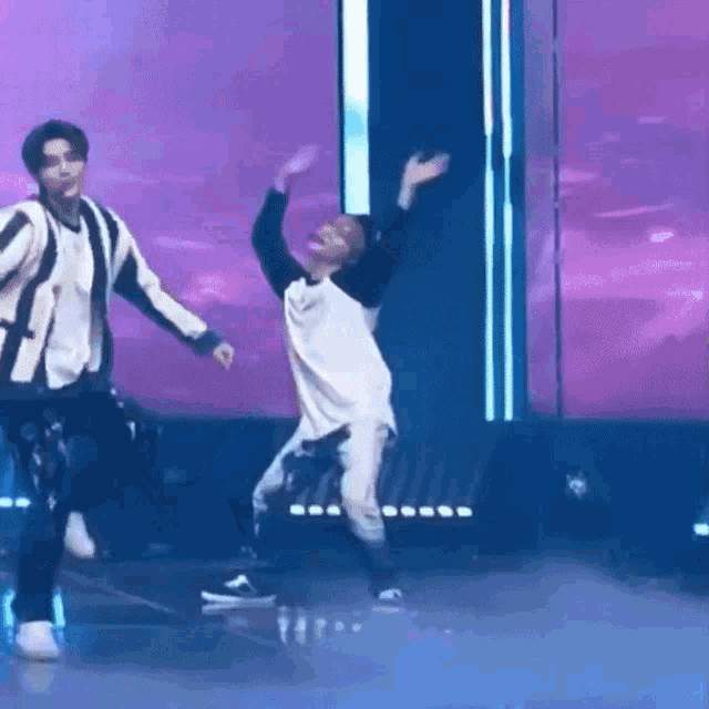 a couple of men are dancing on a stage .