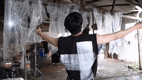 a man with his arms outstretched is wearing a black tank top with a white patch on the back