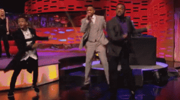 a group of men are dancing on a stage
