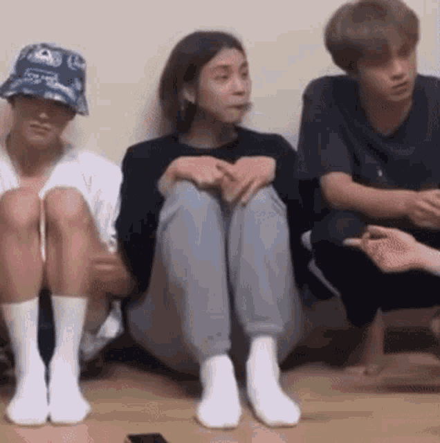 a group of people are sitting on the floor .