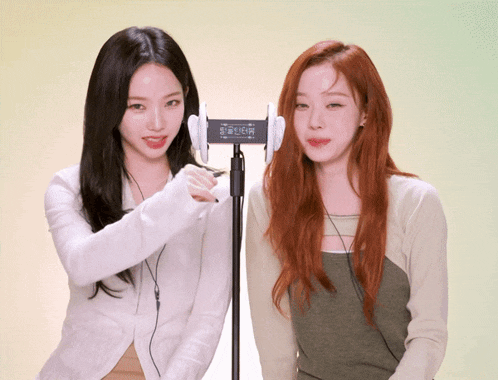 two women are standing next to each other and one has a device in her ear that says ' lg ' on it