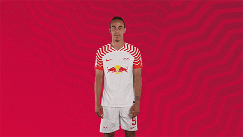 a man wearing a red bull jersey and shorts