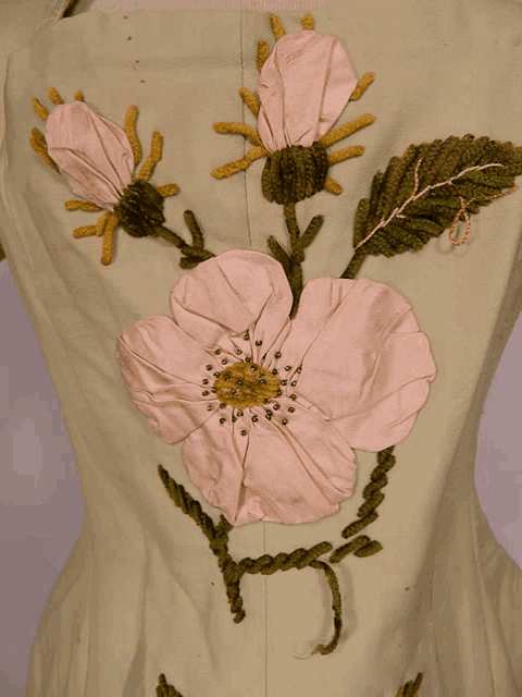 a close up of a flower embroidered on a white cloth