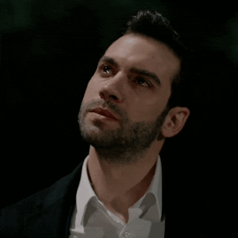 a man with a beard wearing a black suit and white shirt