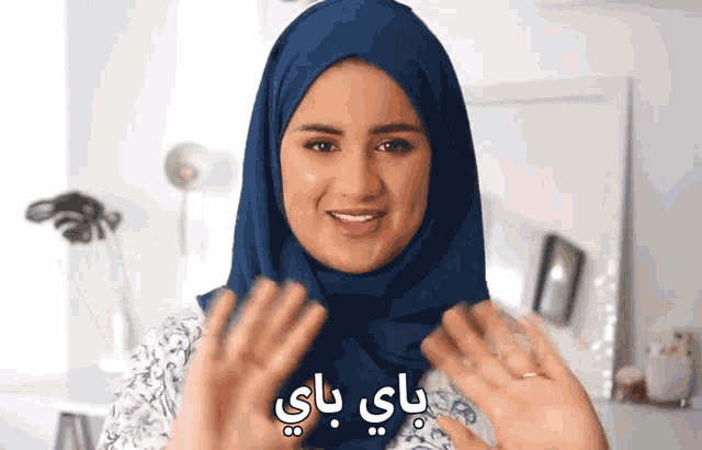 a woman wearing a blue hijab with arabic writing