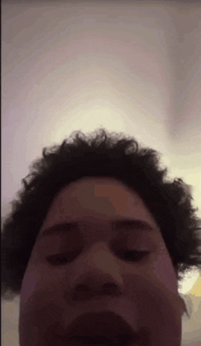 a man with curly hair is making a funny face