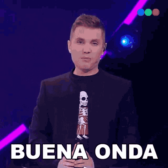 a man wearing a black suit and a skeleton shirt says buena onda