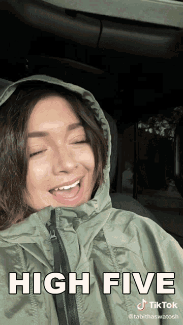 a woman wearing a hooded jacket with the words high five on it