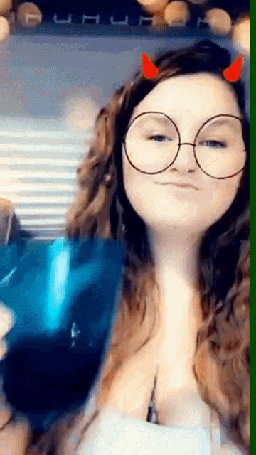 a woman wearing round glasses and red horns