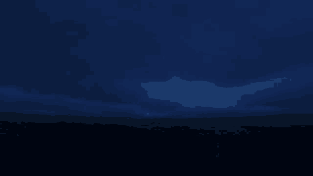a dark blue sky with a few clouds and lightning