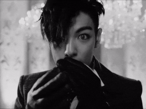 a black and white photo of a man covering his face