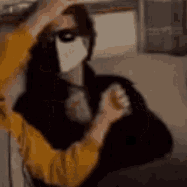 a person wearing a mask is sitting on a couch .