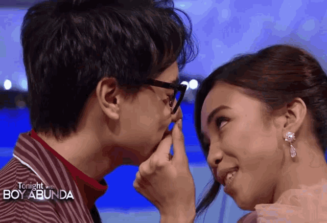 a man kissing a woman 's forehead with the words tonight with boy abunda on the bottom