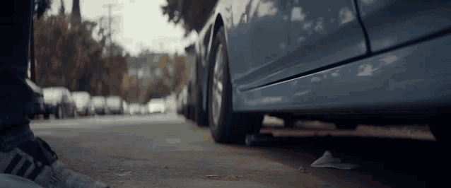 a person standing next to a car with their feet on the ground
