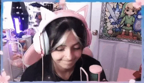 a woman wearing headphones and a cat ear headband is sitting in a chair .