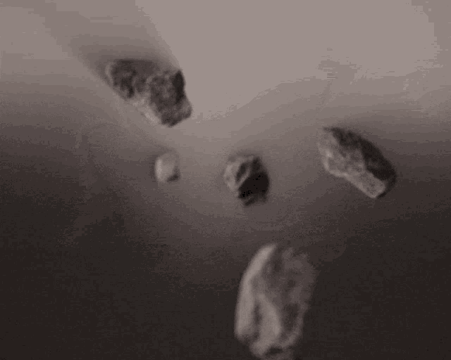 a black and white photo of rocks falling from the ceiling