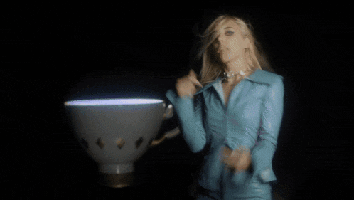 a woman with blonde hair is wearing a blue jacket