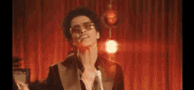 a man in a suit and sunglasses is dancing on a stage .