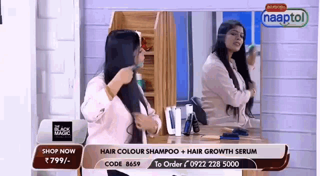 a woman is brushing her hair in front of a mirror on a television show .