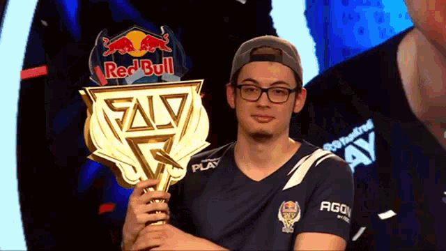 a man holding a trophy that says red bull