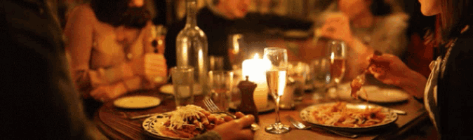 a group of people sitting at a table eating food